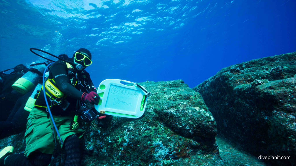 Dive guide with slate at Monument diving Yonaguni with Sou-Wes Diving Okinawa Japan Diveplanit 1017