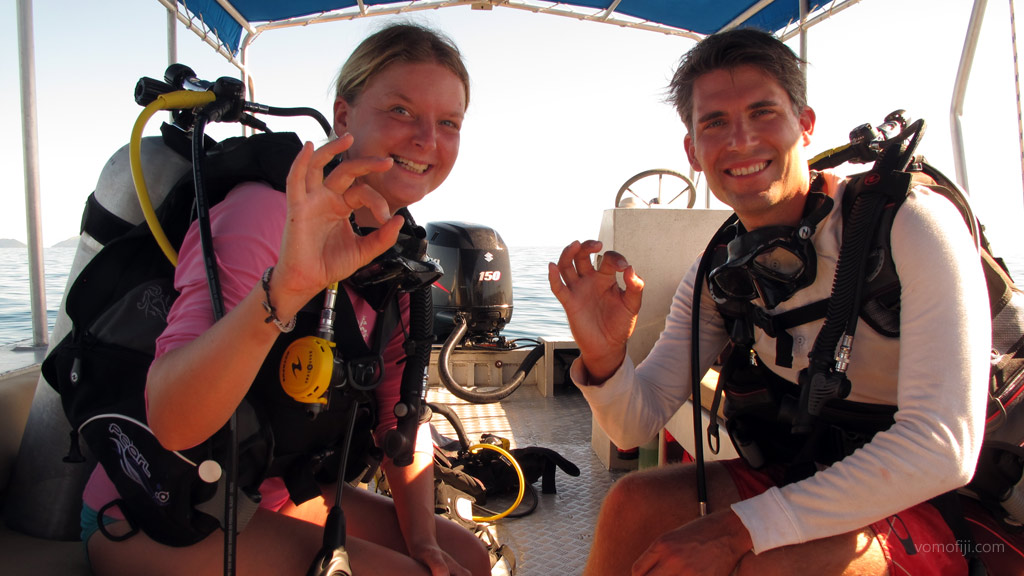 Diving couple on covered boat diving Vomo with Vomo Island Resort PADI dive centre in the Fiji Islands by Diveplanit