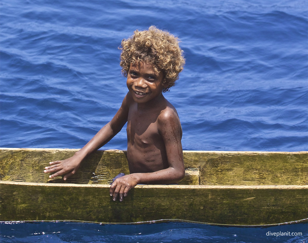A happy little Solomon Islands kid in a canoe visits our boat the MV Bilikiki
