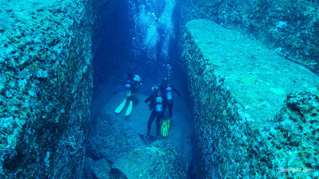 Divers in the slot at Monument diving Yonaguni Okinawa Japan by Diveplanit