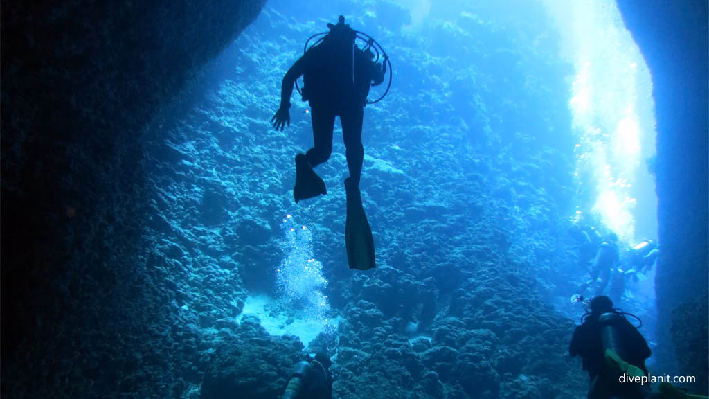 Divers in the entrance diving Batcave at Russell Islands Solomon Islands by Diveplanit