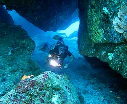 Diver in gap between the massive rocks at hin pusa diving andaman sea feature